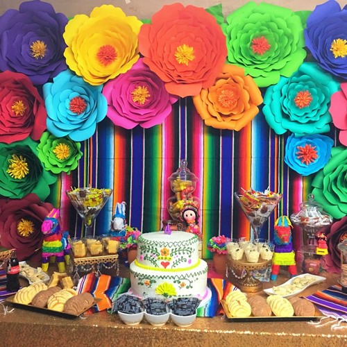 Kleurrijke papieren bloemen boven een feesttafel