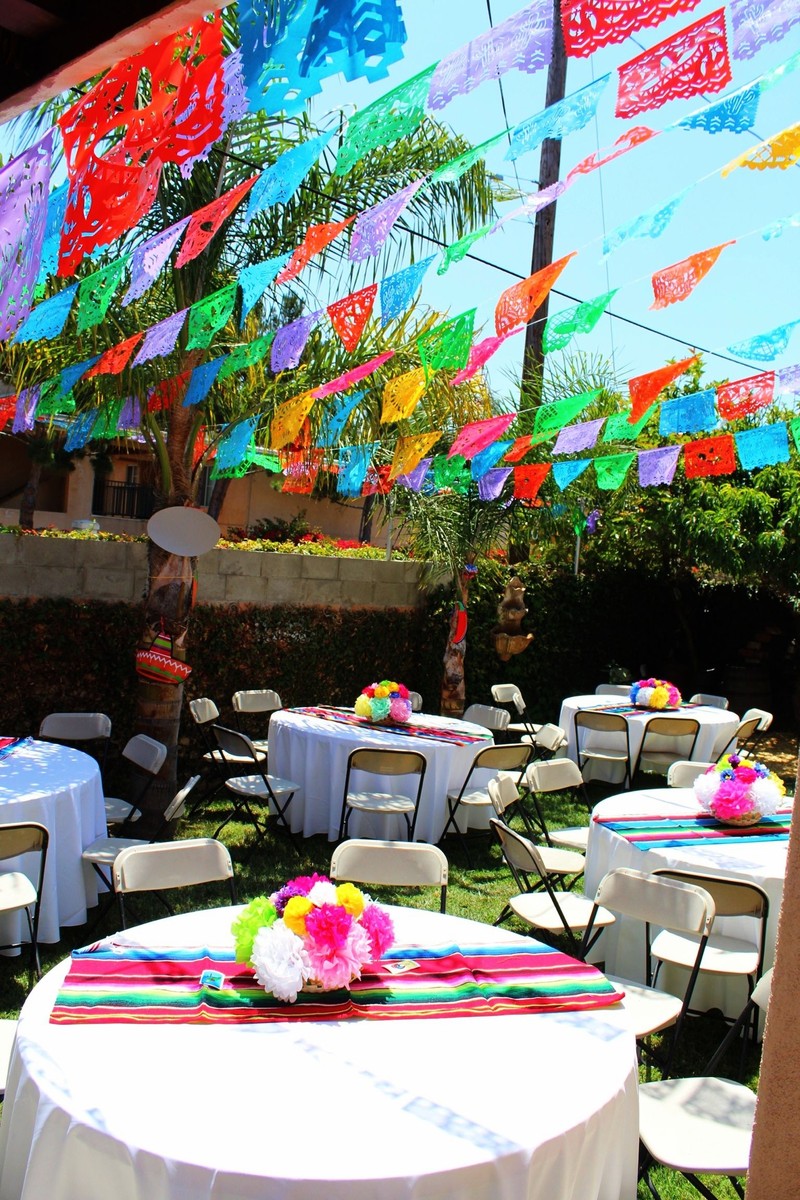 Papel picado boven feestelijk gedekte tafels